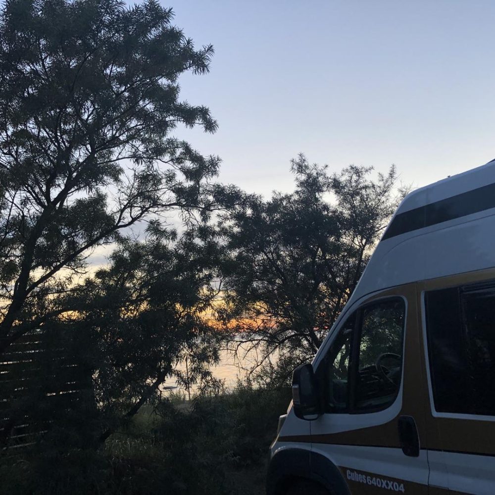 Campervan na plaży w Łotwie podczas zachodu słońca